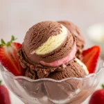 Chocolate vanilla strawberry ice cream scoops in a bowl.