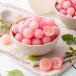 Pink Cotton Candy Grapes on a white background, showcasing their vibrant color and unique, sweet flavor.